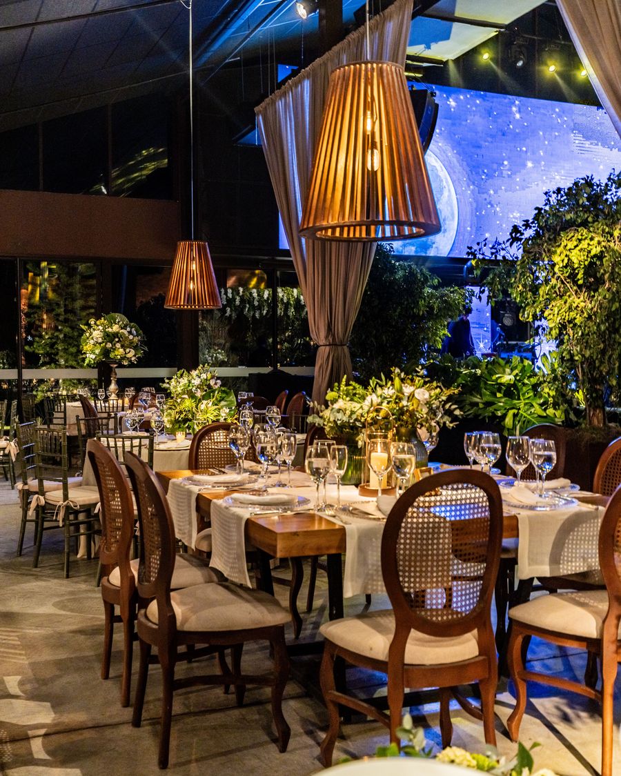 Salão de restaurante com pendentes de madeira sobre as mesas